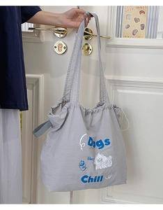 Detail of grey drawstring canvas tote bag featuring dog illustration and Chill slogan