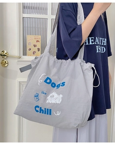 Detail of grey canvas tote bag with drawstring closure and cute dog print illustration