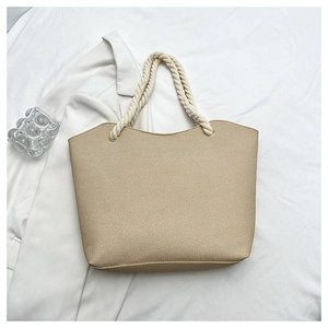 Gros plan d'un sac cabas en toile beige avec anses en corde épaisse et œillets dorés
