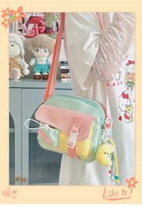 Dettaglio borsa a tracolla in tela color-block con cinturino regolabile e ciondolo a luna