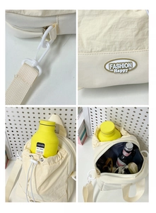 Detail view of cream nylon crossbody bag featuring drawstring closure and fashion logo