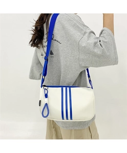 Detail der weißen Oxford-Tasche mit blauen Streifen, Riemen und Modeschild-Verzierung