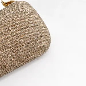 Close-up of champagne gold sequined fabric and metallic clasp on evening clutch