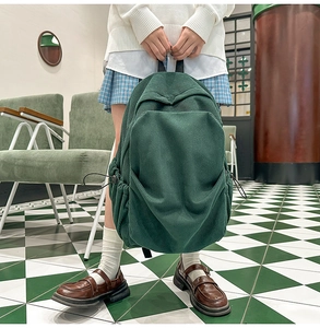 Close-up of vintage dark green corduroy backpack with textured vertical stripes