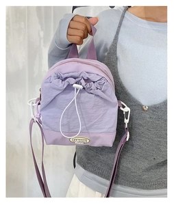 Detail of purple nylon mini bag with drawstring pocket and fashion logo plaque