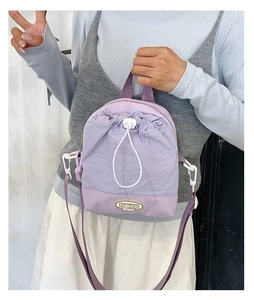Detail of lavender nylon crossbody bag with drawstring closure and FASHION Happy emblem