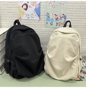Close-up of black and beige corduroy backpacks featuring large pockets and strap details