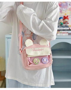Detail view of the pink bunny-ear ita bag with transparent pocket and anime badges