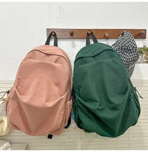 Detailed view of corduroy texture on pink and green college style backpacks