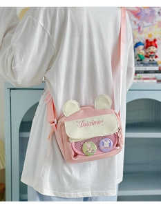 Detailed back view of pink cartoon crossbody bag with transparent pocket and bunny badges
