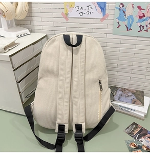 Detail view of corduroy backpack showing padded straps and side hidden zipper pocket