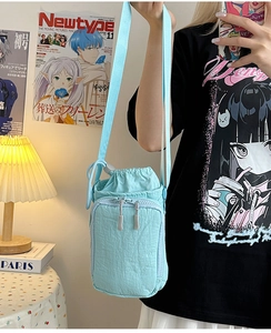 Detail der hellblauen Nylon-Beuteltasche mit Kordelzug, Reißverschlussfach und Gurt