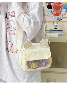 Detail of cute cream canvas crossbody bag with bear ears and transparent mesh pocket