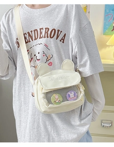 Detail of cream white canvas crossbody bag featuring cute animal ears and mesh pocket