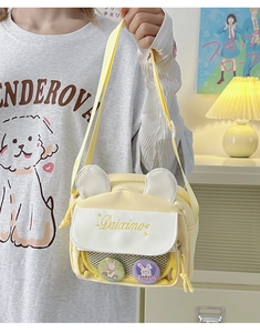 Detail of yellow canvas ita bag with rabbit ears, embroidery and clear window pocket