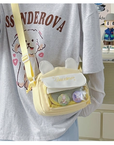 Detail of yellow crossbody bag with cute bunny ears and clear window for pins