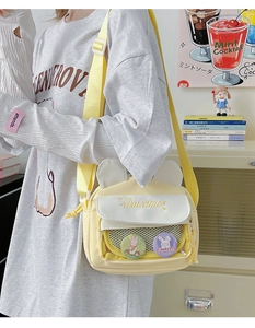 Close-up of yellow canvas bag with rabbit ears, embroidery details and cute badges