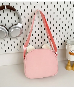 Close-up of pink canvas children's bag with cute beige ears on a white pegboard background