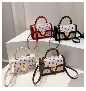 Set of strawberry print crossbody bags in red black cream and brown on white pedestals