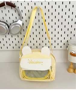 Detail of yellow canvas crossbody bag featuring cute cat ears and a front mesh pocket