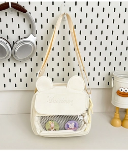 Detail of cream white canvas mini bag with 3D bear ears and clear mesh pocket design