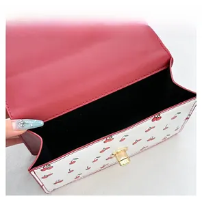 Detailed interior view showing black velvet lining and golden twist lock on cherry print bag