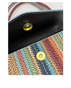 Detailed macro of woven zigzag pattern with golden magnetic closure on small square bag