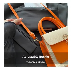 Detail of adjustable metal buckle and contrast strap on the orange stylish handbag
