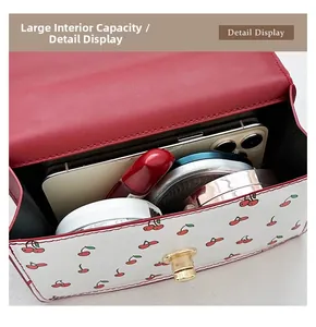 Detail view of the mini cherry print bag interior showing storage for phone and makeup