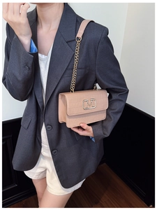 Detalle de bolso beige con patrón de cocodrilo hebilla M dorada y correa de cadena