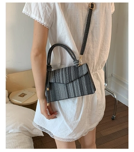 Detailed view of woven crossbody bag with striped texture and adjustable shoulder strap