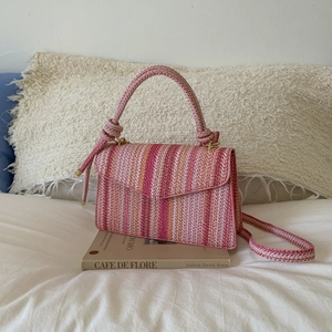 Pink and orange striped woven handbag with round top handle and long shoulder strap
