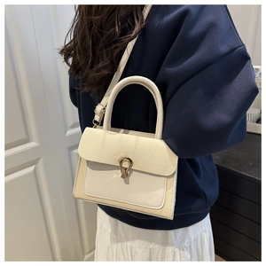 Detail of cream woven and leather crossbody bag with elegant gold U-shaped metal buckle
