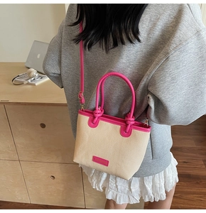 Detail of mini straw beach bag with pink leather trim and adjustable crossbody strap