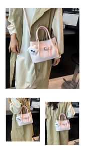 Close-up of pink woven texture bucket bag with metal buckle and plush charm detail