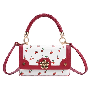White leather handbag with red cherry print and golden flower lock on white background
