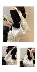 Close-up of intricate lace flower embroidery and floral print on white canvas tote bag