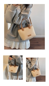 Detail der Stroh-Eimertasche mit braunem Lederbesatz und verstellbarem Schultergurt