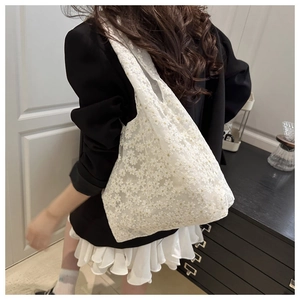 Detailed close-up of white lace tote bag with 3D floral embroidery and soft fabric texture