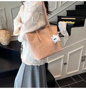 Détail du sac cabas en similicuir rose avec gaufrage floral et breloque en peluche