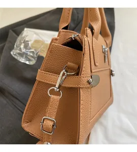 Detail of silver metal hook and adjustable strap on lychee grain leather handbag