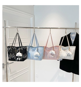 Detail view of four colorful textured tote bags featuring wave patterns and plush charms
