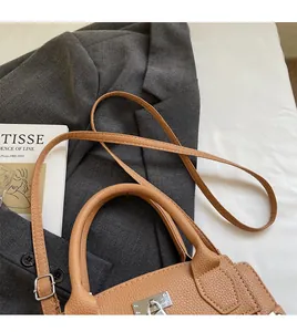 Detail of brown lychee leather texture and silver buckle on a classic handbag