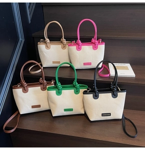 Mehrfarbige Stroh-Schultertaschen in Khaki, Grün und Rosa auf einer eleganten Treppe