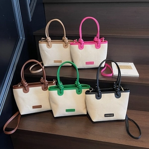 Cinco colores de bolsos de playa de lona con ribetes de cuero y asas con nudos
