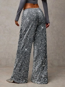 Close-up of sparkling silver sequins on high-waist wide-leg trousers for party wear