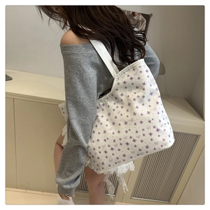Detail of floral tote bag shown on shoulder highlighting large capacity and size