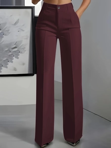 Detail view of high-waisted burgundy wide-leg trousers with elegant front pleat design