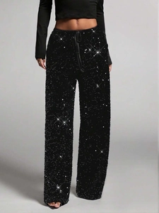 Detail of high-waist sequin trousers featuring a shimmering finish and adjustable drawstring