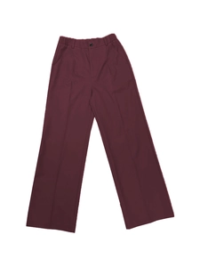 Detailed view of burgundy high-waisted wide-leg trousers with front pleats and side pockets